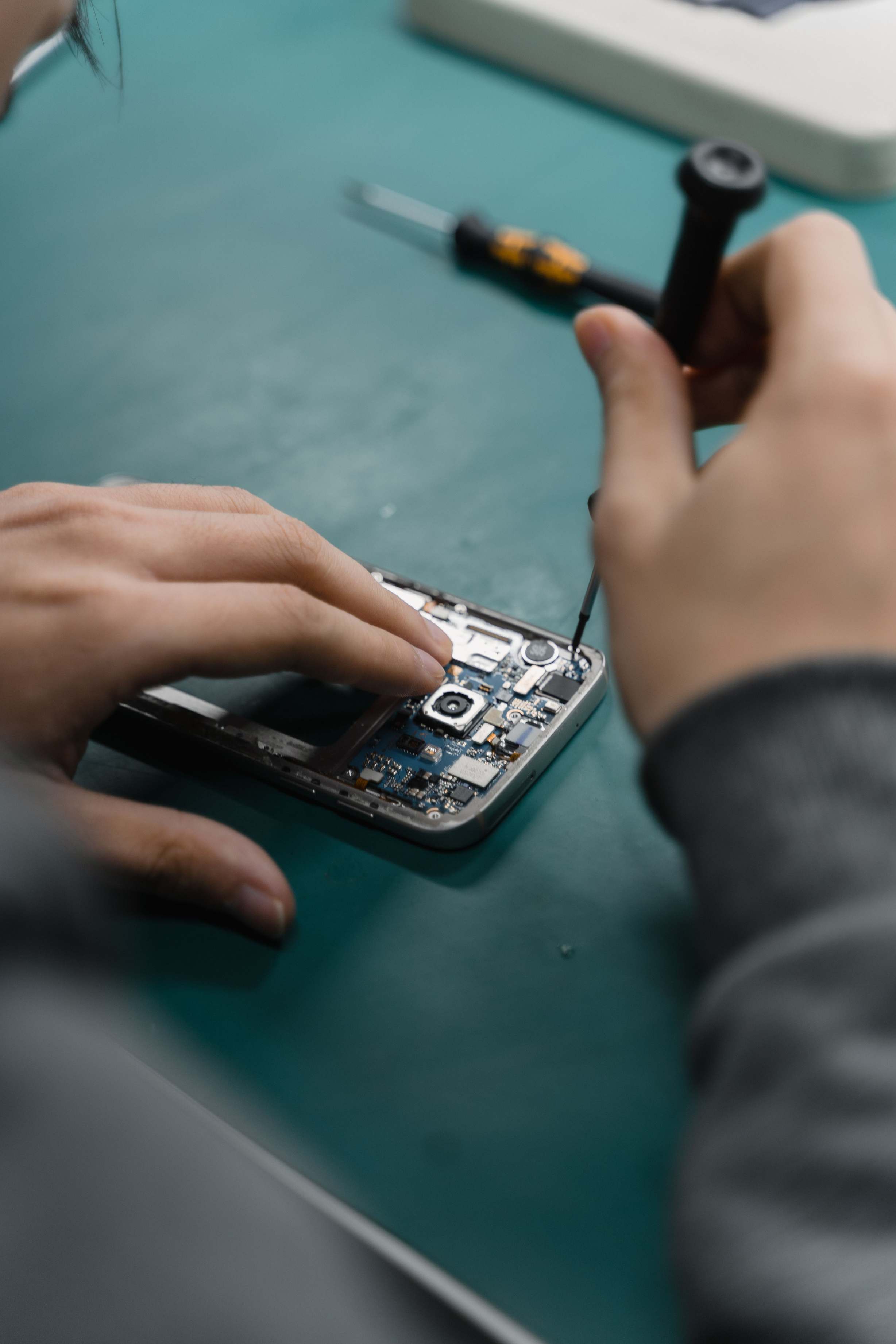สมาร์ทโฟนและองค์ประกอบฮาร์ดแวร์ด้านความปลอดภัย — repairing smartphone circuit board